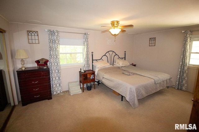 carpeted bedroom featuring multiple windows and ceiling fan