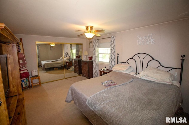 carpeted bedroom featuring ceiling fan and a closet