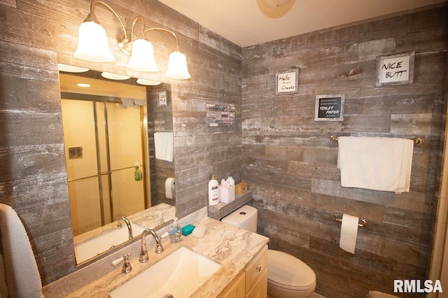 bathroom featuring wood walls, vanity, and toilet