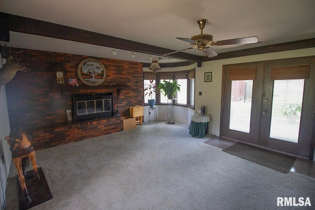 unfurnished living room with beam ceiling, a fireplace, carpet flooring, and ceiling fan