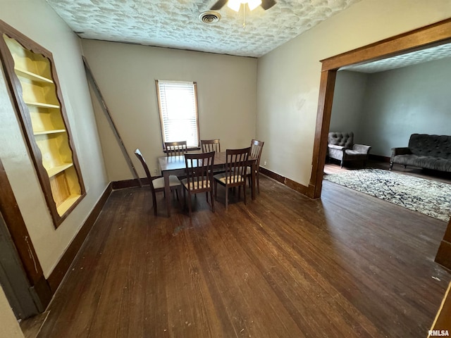 dining room with a textured ceiling, ceiling fan, and dark wood-type flooring