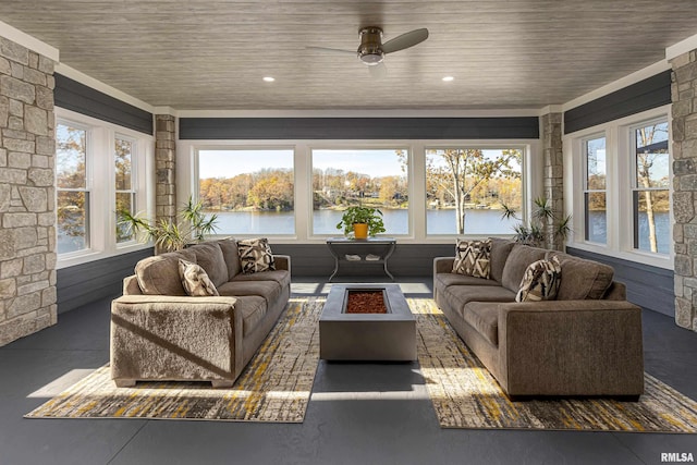 sunroom with ceiling fan, a water view, and wooden ceiling