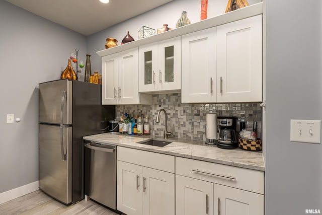 kitchen featuring white cabinets, light stone counters, sink, and stainless steel appliances