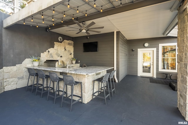 view of patio featuring ceiling fan, an outdoor stone fireplace, and a wet bar