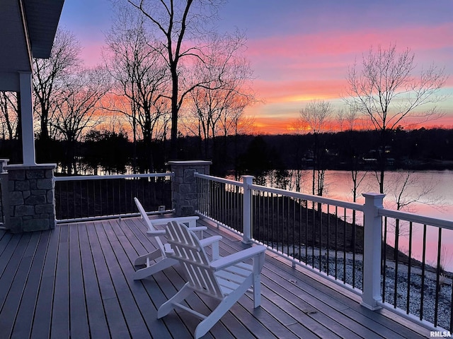 deck at dusk featuring a water view