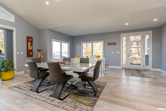 dining area with light hardwood / wood-style floors and vaulted ceiling