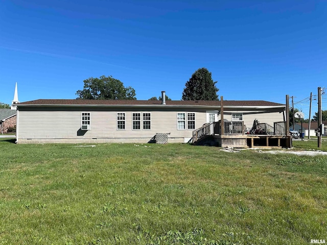 rear view of property featuring a wooden deck and a lawn