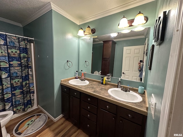 bathroom with crown molding, hardwood / wood-style flooring, vanity, and toilet