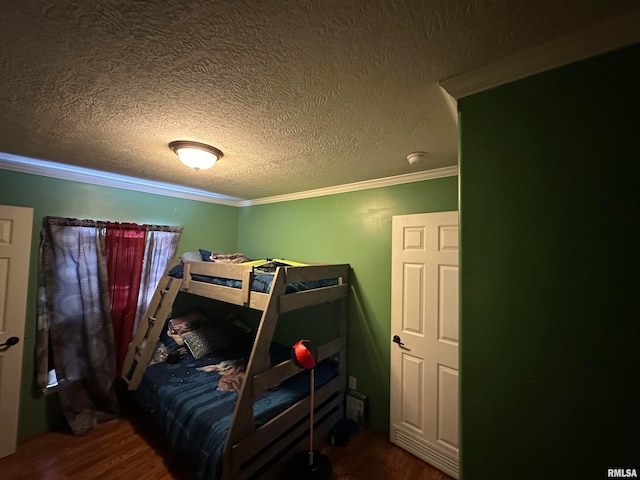 bedroom featuring a textured ceiling, hardwood / wood-style floors, and crown molding