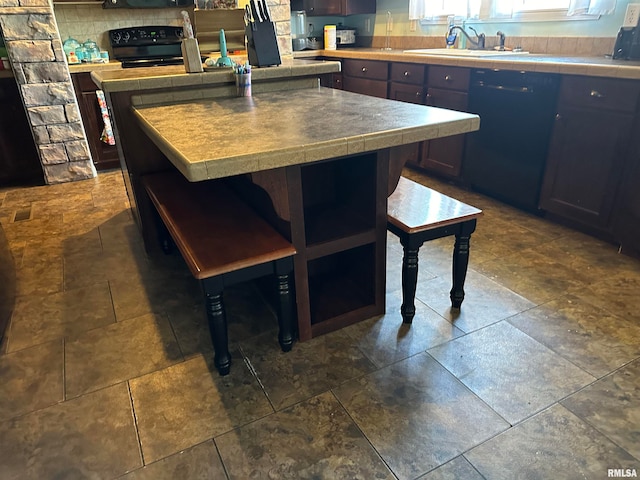 kitchen with a kitchen breakfast bar, decorative backsplash, black appliances, a center island, and sink