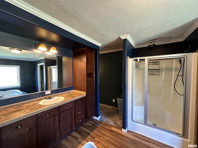 bathroom featuring vanity, walk in shower, crown molding, a textured ceiling, and hardwood / wood-style flooring