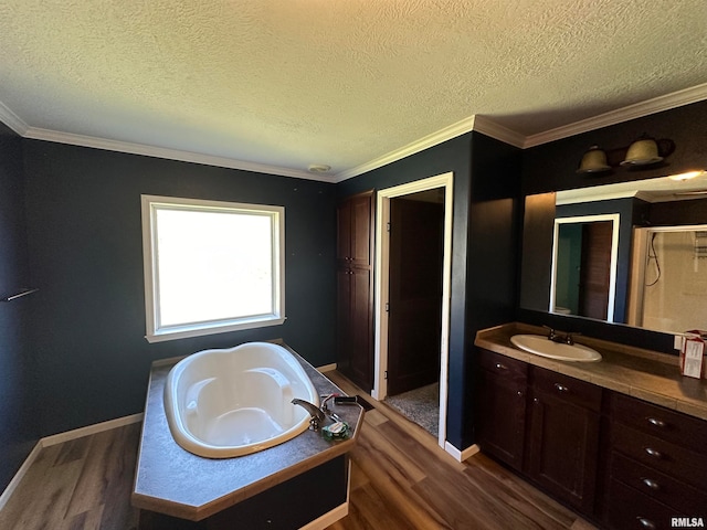 bathroom with plus walk in shower, wood-type flooring, a textured ceiling, crown molding, and vanity