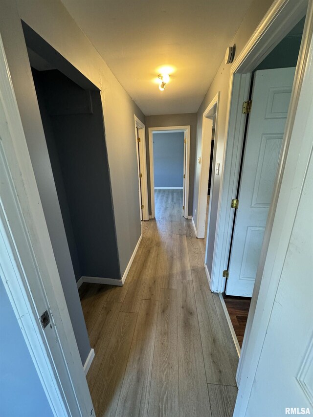 hall featuring wood finished floors and baseboards