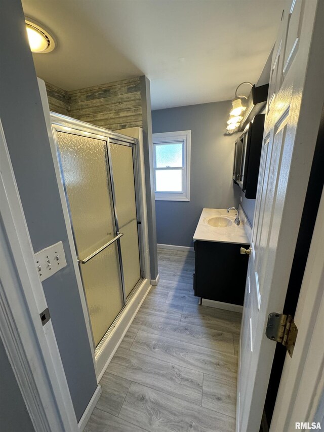 full bath with vanity, a stall shower, and baseboards