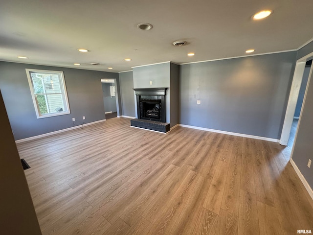 unfurnished living room featuring light hardwood / wood-style floors and crown molding