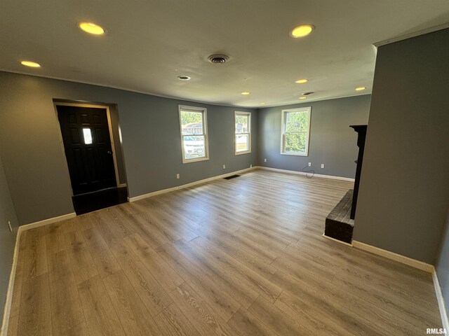 unfurnished living room with recessed lighting, light wood-style floors, and baseboards