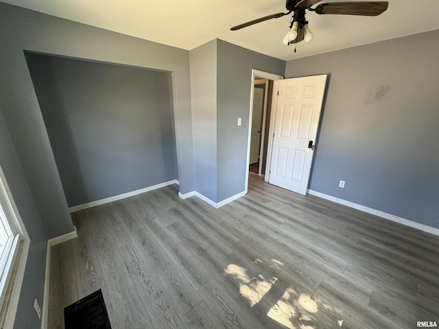 unfurnished bedroom featuring wood finished floors, baseboards, and ceiling fan