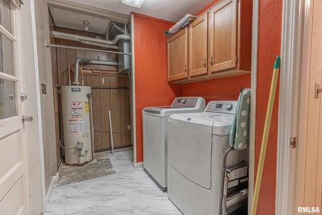 clothes washing area with washer and dryer, cabinets, and gas water heater