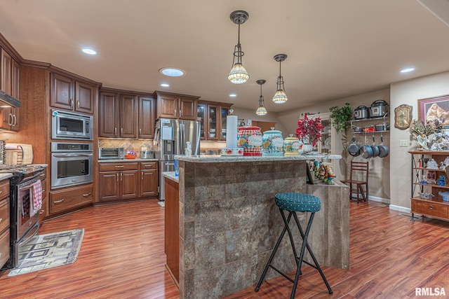 2022 W Main St, Salem, IL 62881 - kitchen featuring a kitchen island, stainless steel appliances, a breakfast bar area, and wood finished floors