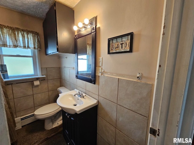 bathroom featuring vanity, toilet, a baseboard radiator, and a wealth of natural light