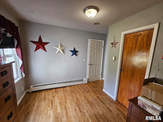 interior space featuring baseboard heating and light hardwood / wood-style flooring