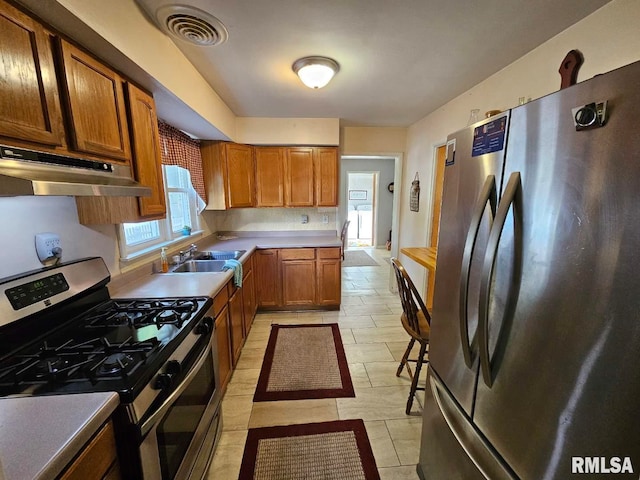 kitchen featuring appliances with stainless steel finishes, sink, and light tile patterned floors