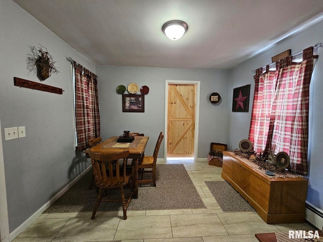 tiled dining space with a baseboard heating unit