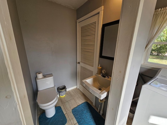 bathroom with toilet, washer / dryer, and sink