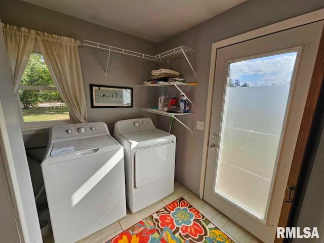 clothes washing area featuring light tile patterned floors and washer and clothes dryer