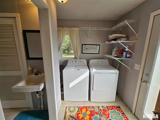 laundry area with light tile patterned floors, sink, and washer and dryer