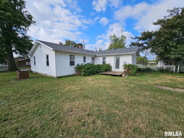 rear view of house featuring a lawn and a deck