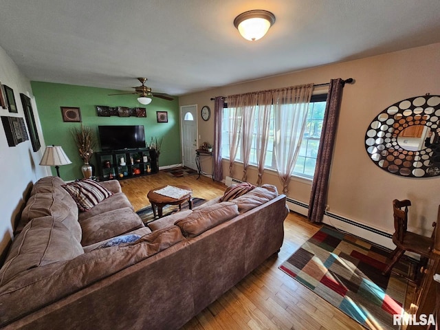 living room with baseboard heating, ceiling fan, and light hardwood / wood-style flooring