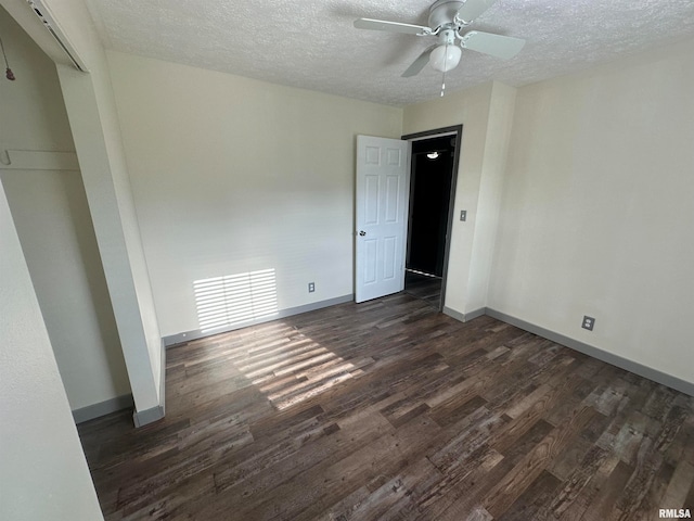 unfurnished bedroom featuring ceiling fan, dark hardwood / wood-style floors, and a textured ceiling