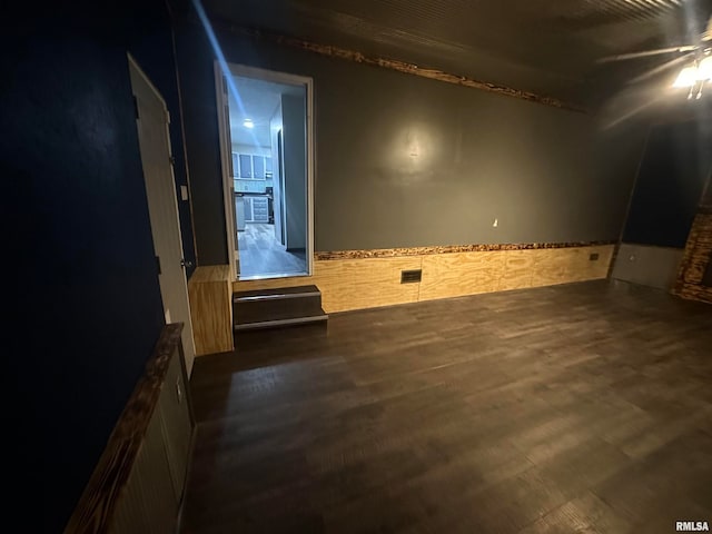 empty room with ceiling fan and dark hardwood / wood-style flooring