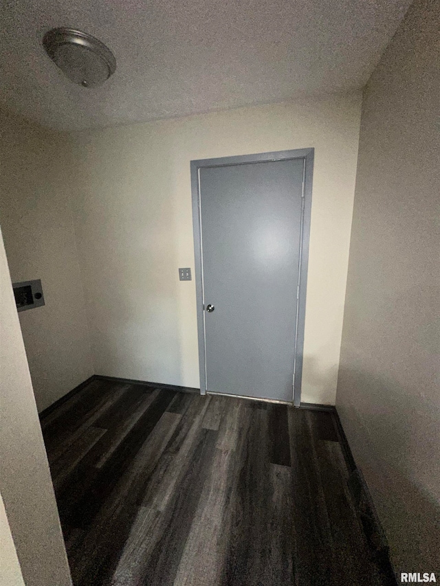 interior space with a textured ceiling and dark hardwood / wood-style flooring