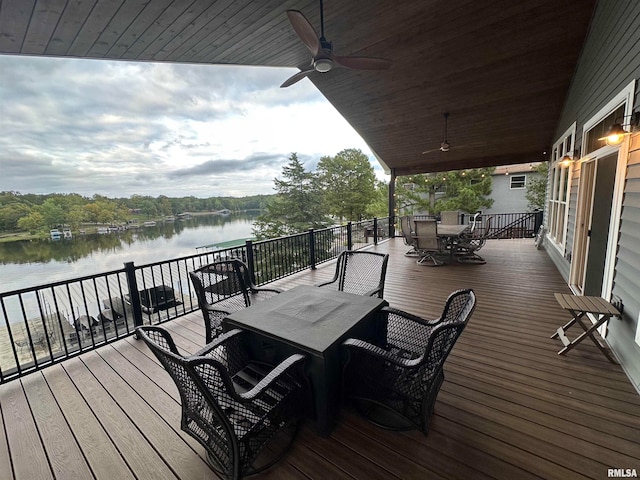 deck with a water view and ceiling fan