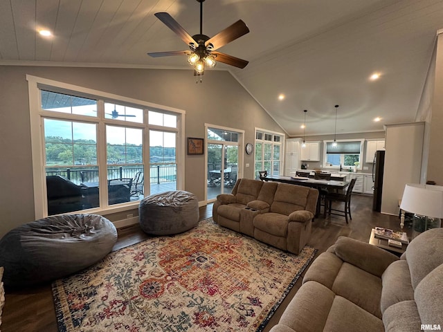 living room featuring ceiling fan, lofted ceiling, dark hardwood / wood-style flooring, and a water view