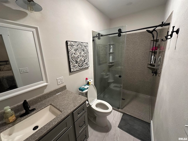 bathroom with vanity, tile patterned flooring, toilet, and a shower with door