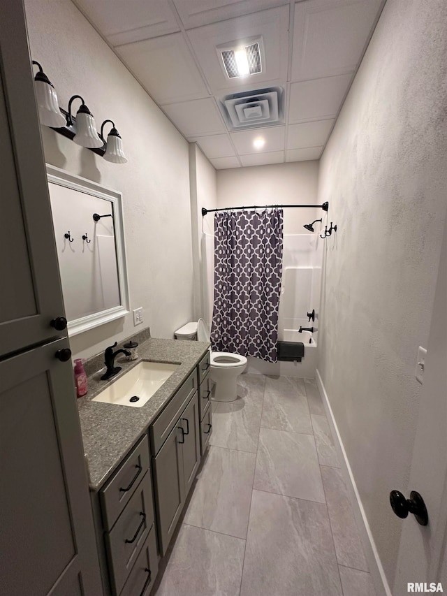 full bathroom featuring a drop ceiling, shower / bath combo, vanity, and toilet