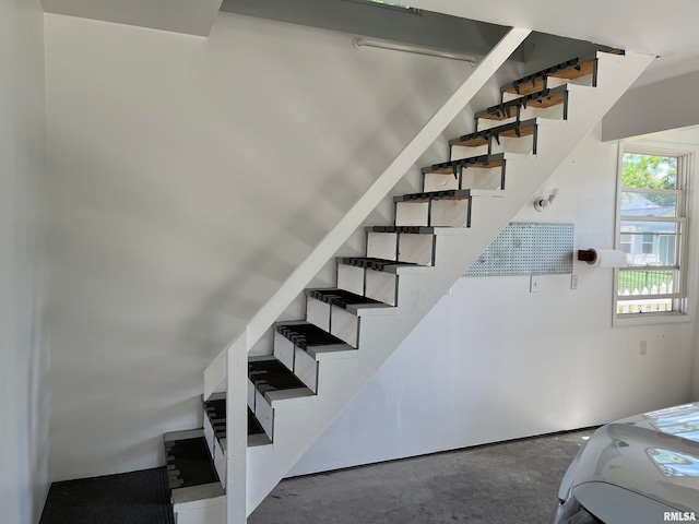 stairs featuring concrete flooring