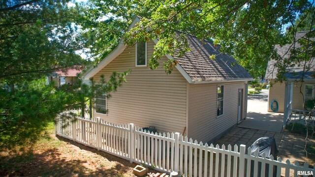1803 N Dawn Dr, Marion, IL 62959 - view of side of property with a shingled roof, a fenced front yard, and a patio area