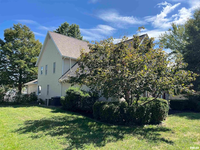 view of side of property with a lawn and central air condition unit