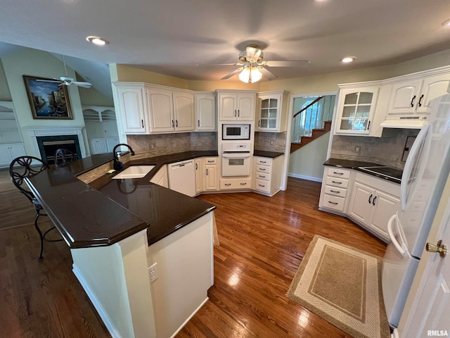 kitchen featuring white cabinets, backsplash, and white appliances