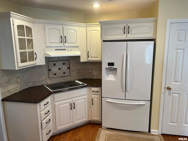 kitchen with black electric cooktop, white cabinetry, white refrigerator with ice dispenser, backsplash, and dark hardwood / wood-style flooring