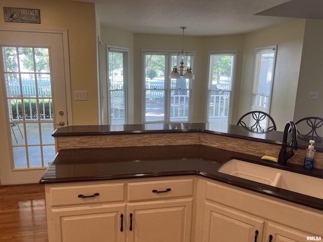 1803 N Dawn Dr, Marion, IL 62959 - kitchen with white cabinetry, a sink, dark countertops, and a chandelier