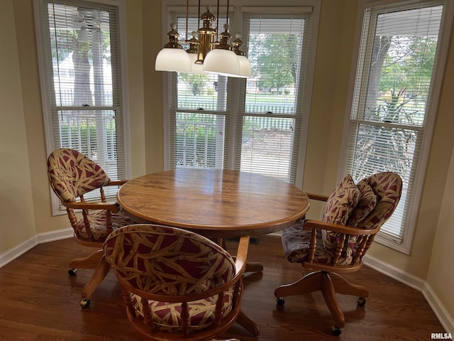 dining area with a notable chandelier, plenty of natural light, and dark wood-type flooring