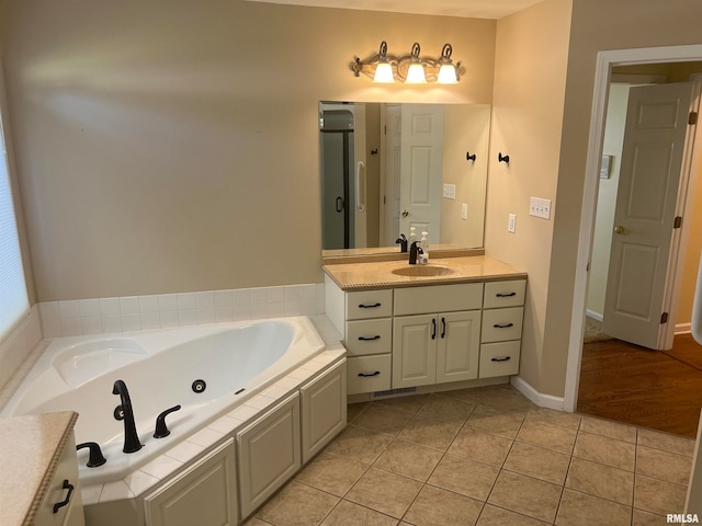 bathroom with plus walk in shower, tile patterned floors, and vanity