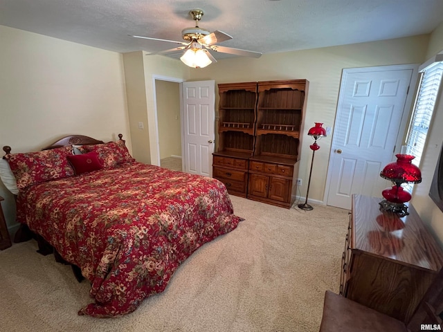 bedroom with ceiling fan, carpet floors, and a textured ceiling