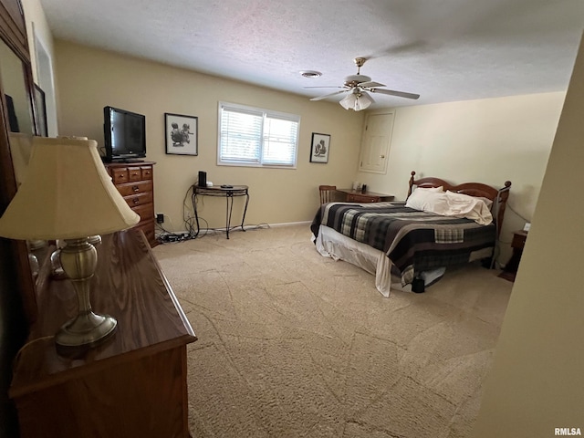 bedroom featuring light carpet, ceiling fan, and a textured ceiling