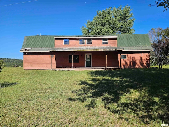 rear view of property with a lawn